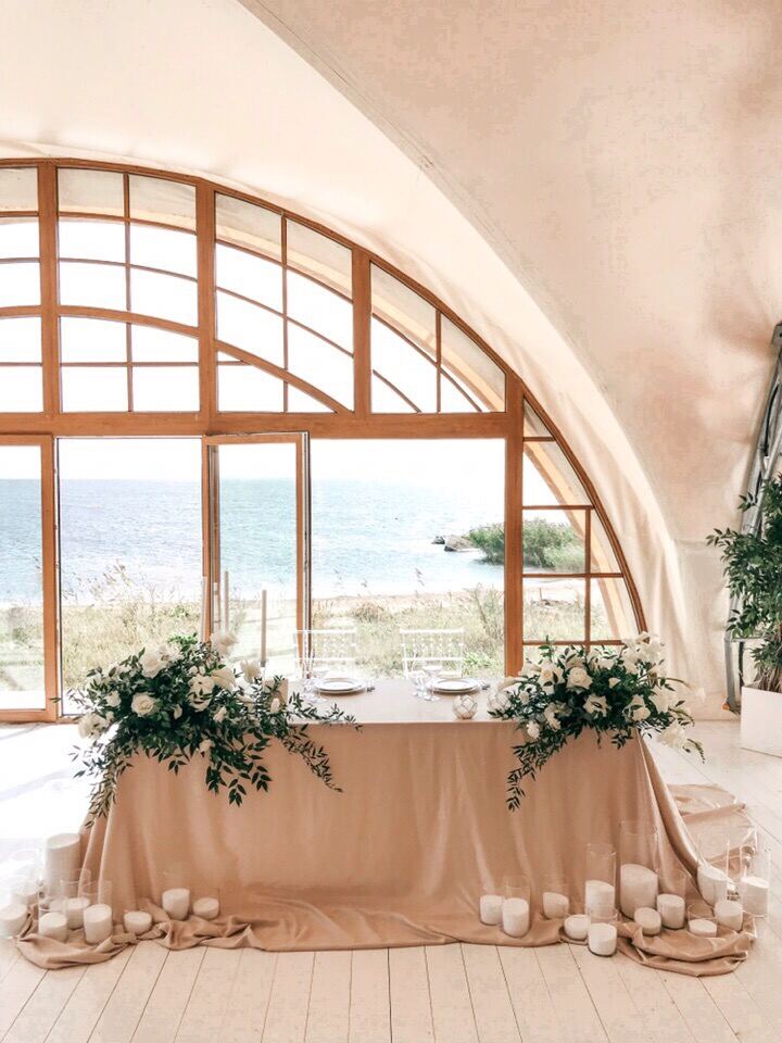 Sweetheart table by an arched sea window